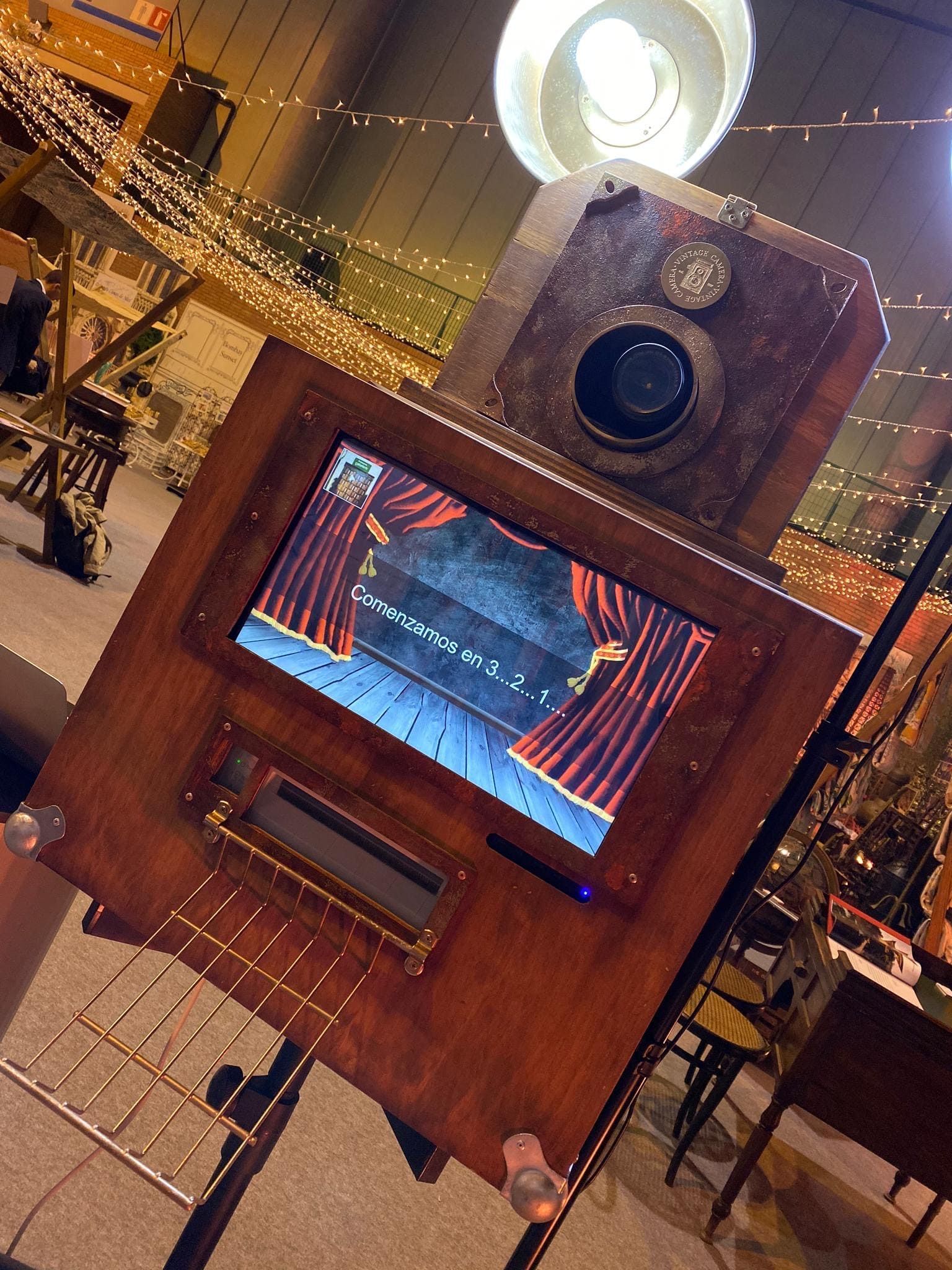 Un fotomatón de madera con una pantalla encima.