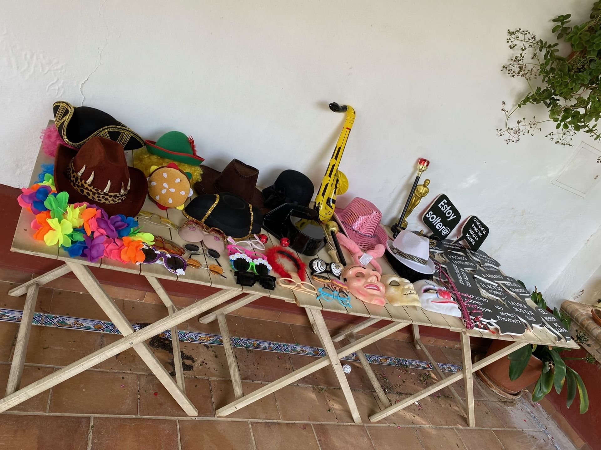 Una mesa de madera con un montón de sombreros y accesorios sobre ella.