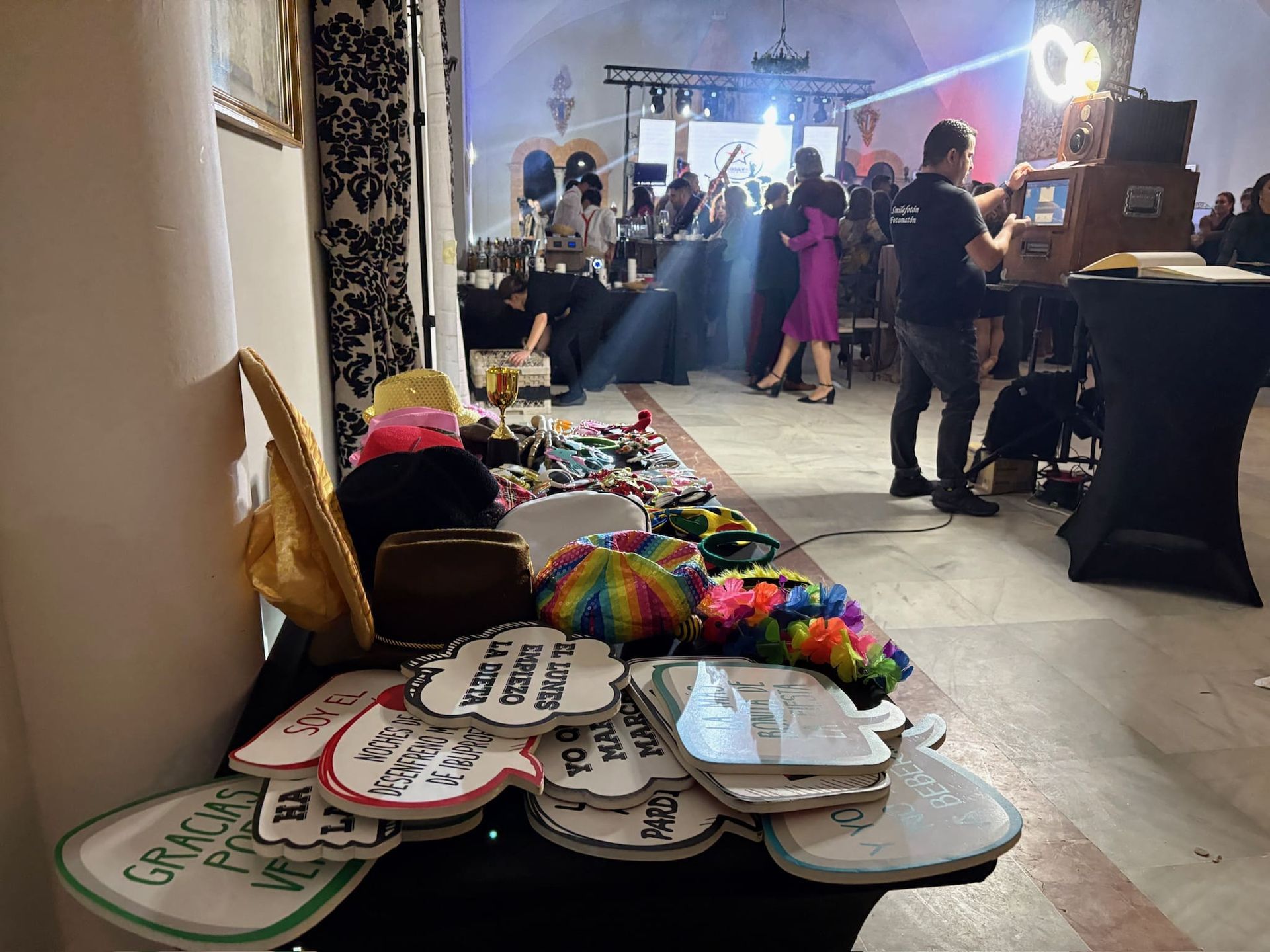 Un grupo de personas están de pie alrededor de una mesa con un montón de accesorios sobre ella.