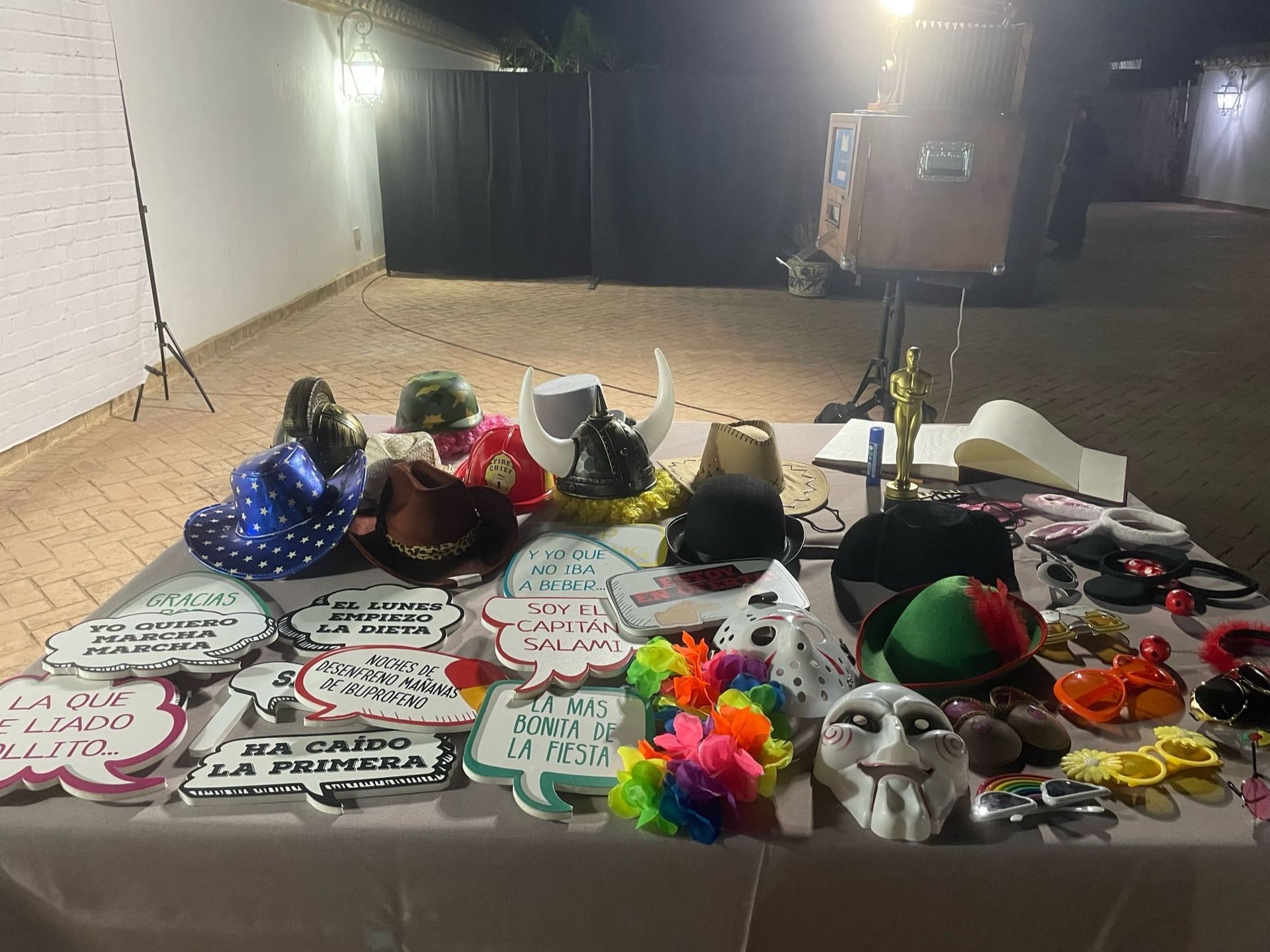 Una mesa cubierta con una variedad de sombreros, máscaras y carteles.