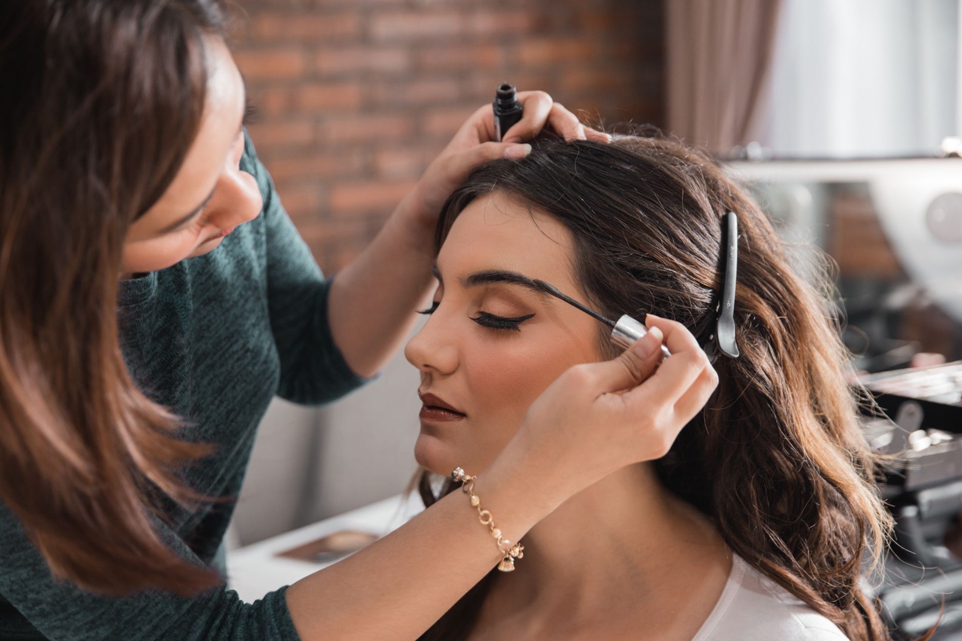 Una mujer se está haciendo un maquillaje para las cejas.