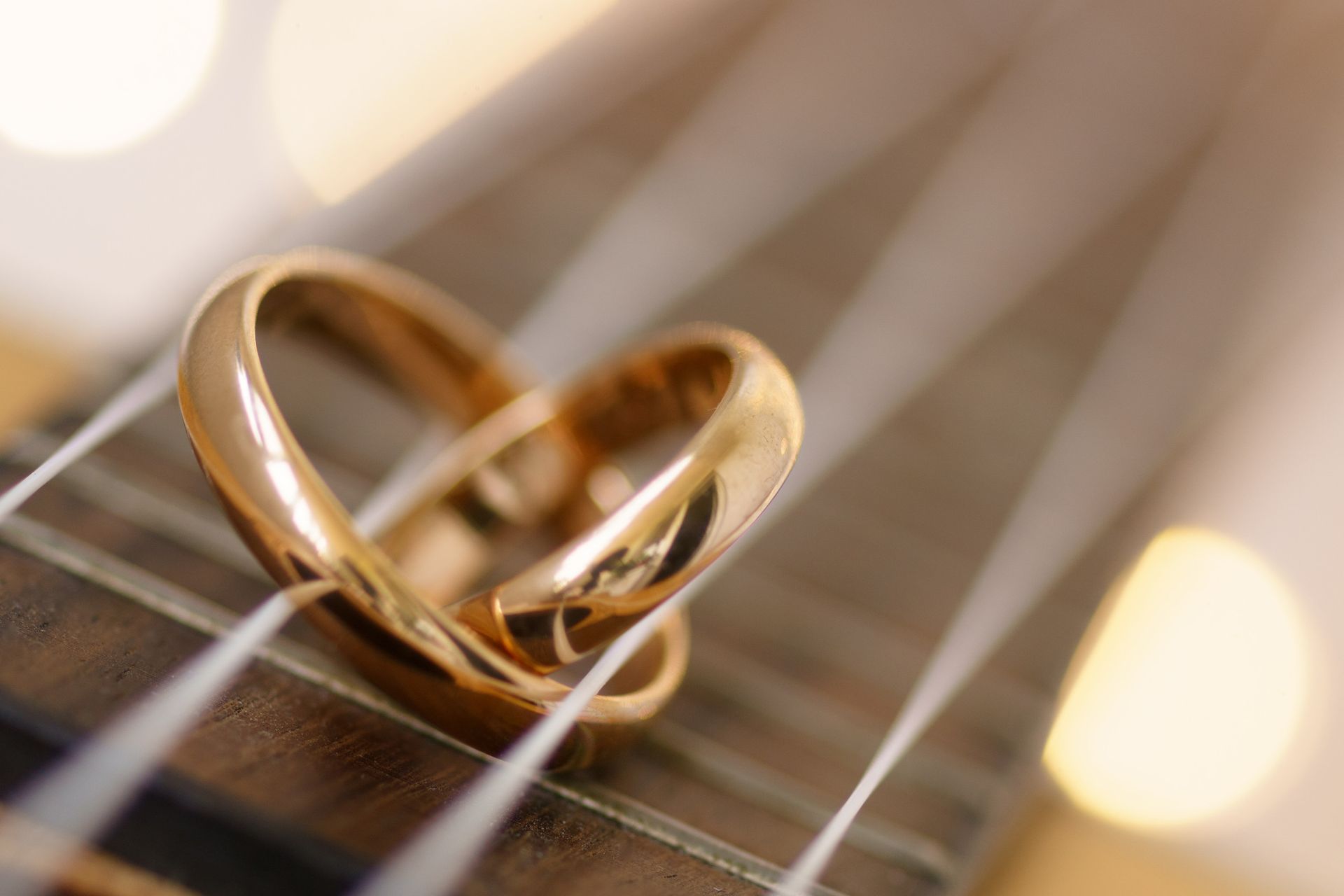 Dos anillos de boda están sentados sobre una cuerda de violín.
