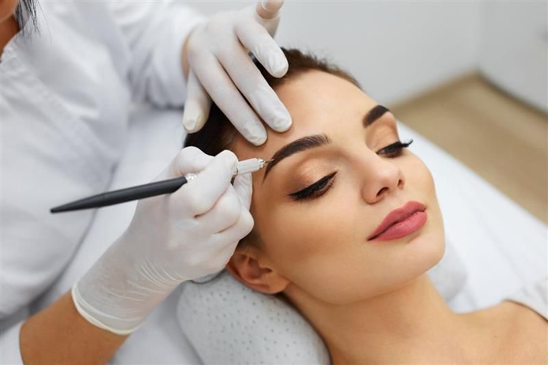Una mujer se está depilando las cejas en un salón de belleza.