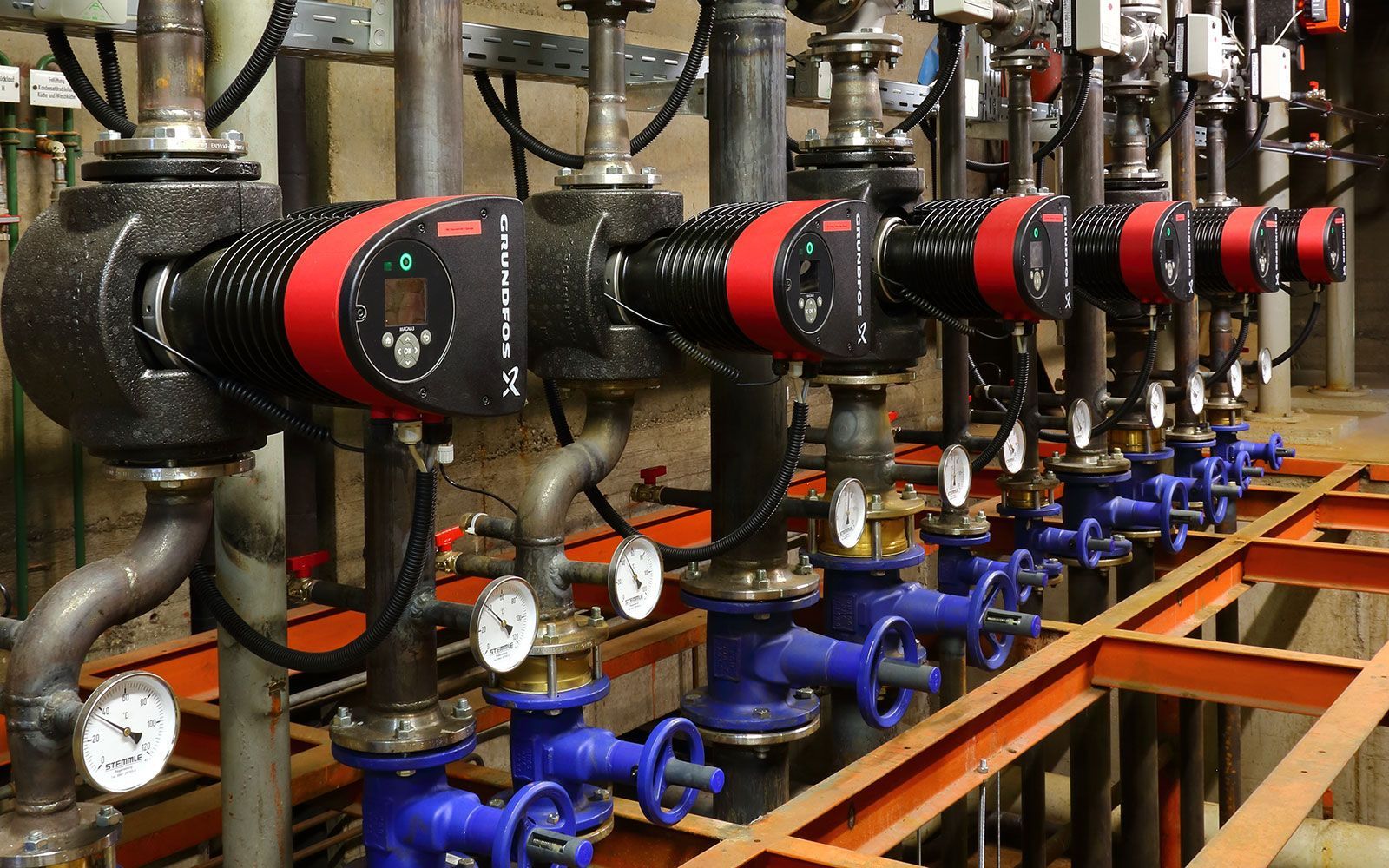Nahaufnahme von Industriemaschinen mit metallischen Bauteilen und gelben Kabeln