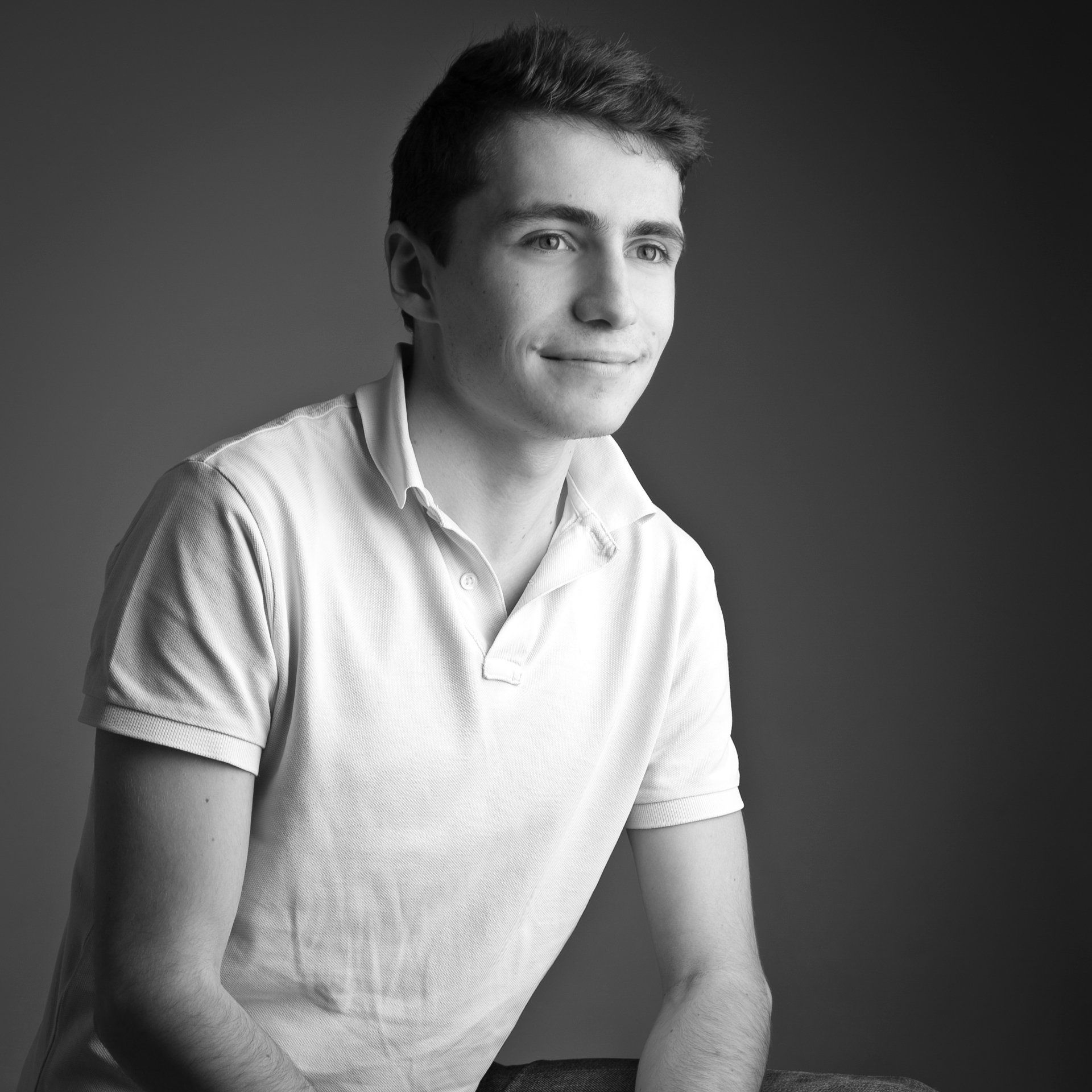 Photo en noir et blanc d'un jeune homme en polo