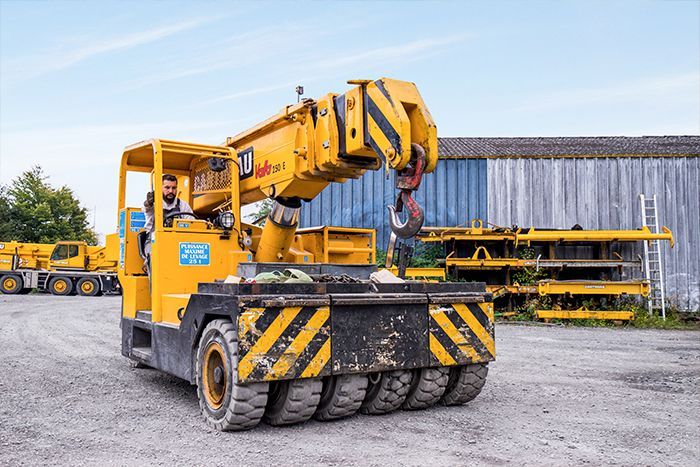 Véhicule compact de levage avec de nombreuses roues à l'avant.