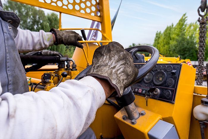 Zoom sur les mains d'un conducteur d'engin.