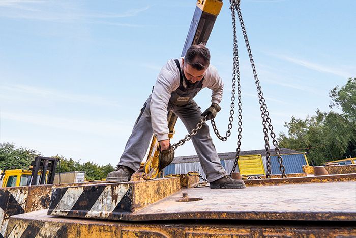 Personnel de l'entreprise Cantiniau en train de fixer le crochet de sa grue sur un autre élément.