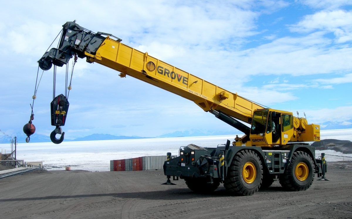 Une grue soulève un grand terrain.