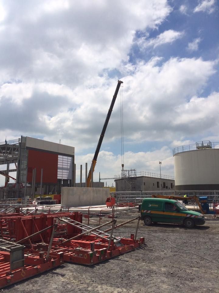 Une grue soulève un gros morceau de métal dans le sol.