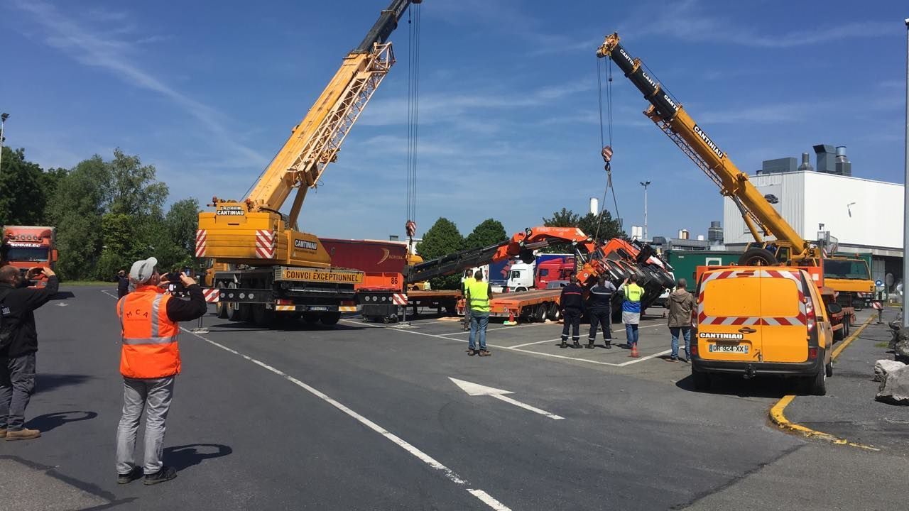 Une grue est soulevée de l'arrière d'un camion.