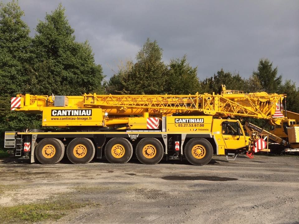 Une grue jaune est garée dans un parking.