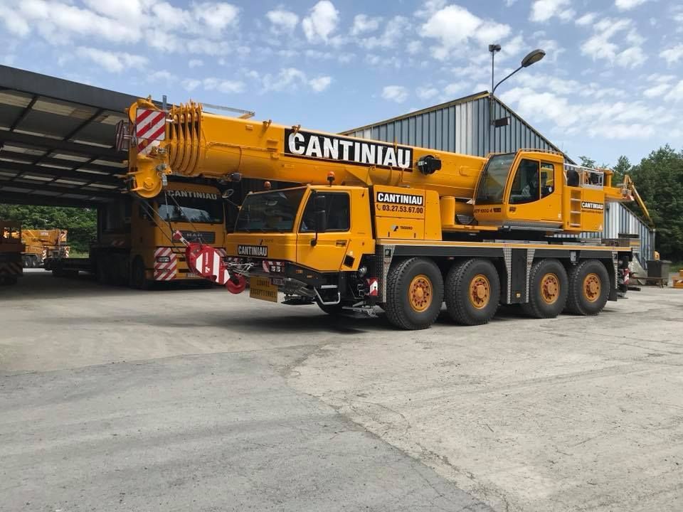 Un camion-grue garé devant un bâtiment.