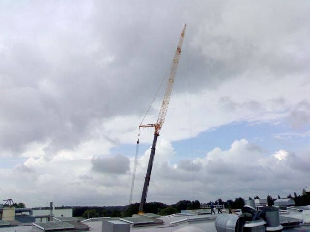 Une grue entièrement déployé avec un ciel nuageux derrière.