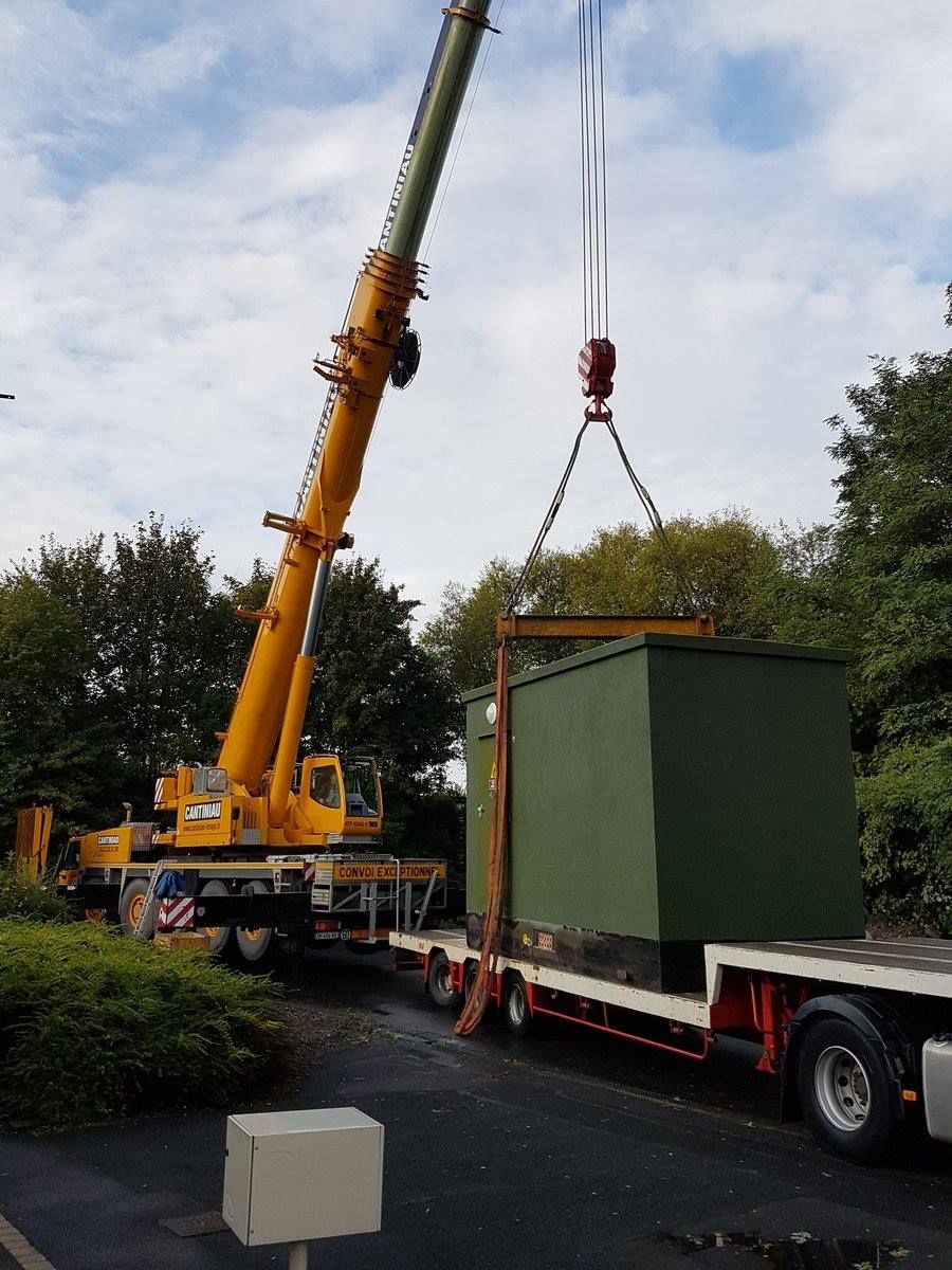 Une grue soulève un conteneur sur un camion.