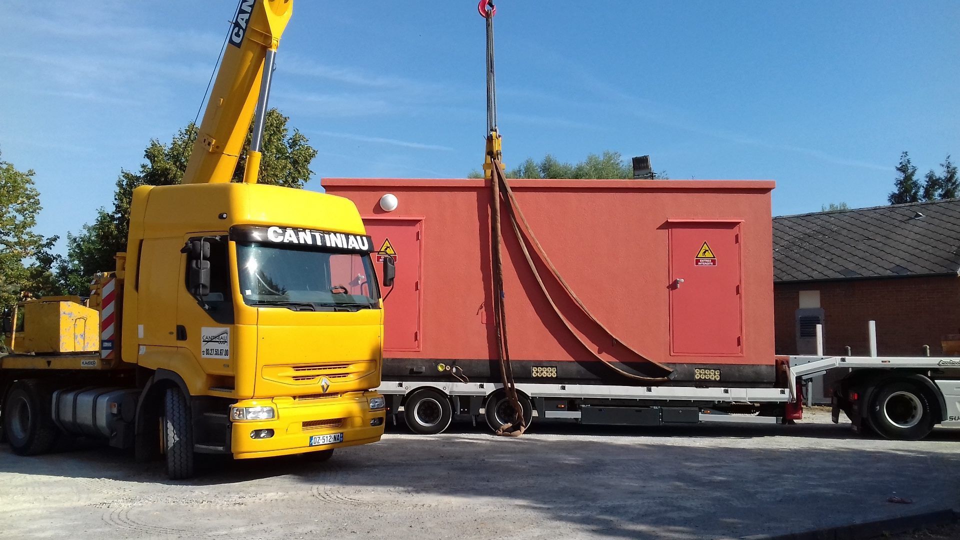 Un grand camion-grue jaune garé dans un parking.