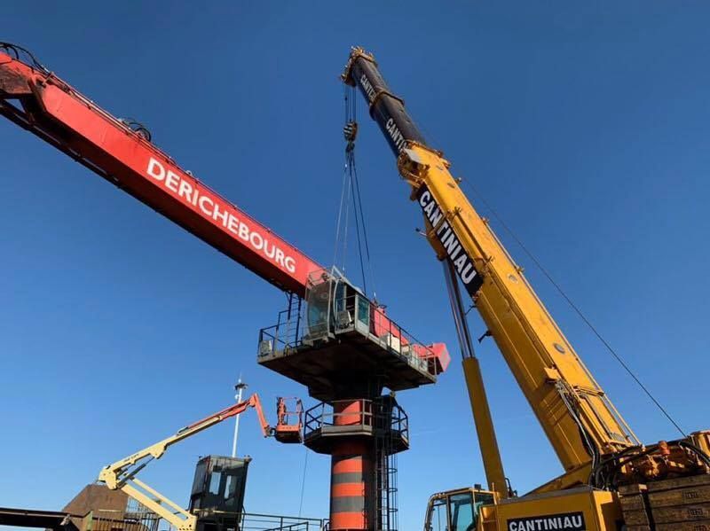 Une grue soulève un gros morceau de bois.