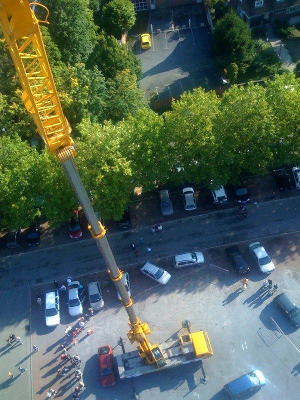 Une grue est au sol près d'un parking.