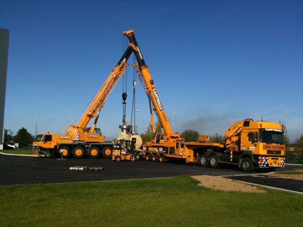 Une grande grue est soulevée par un camion.