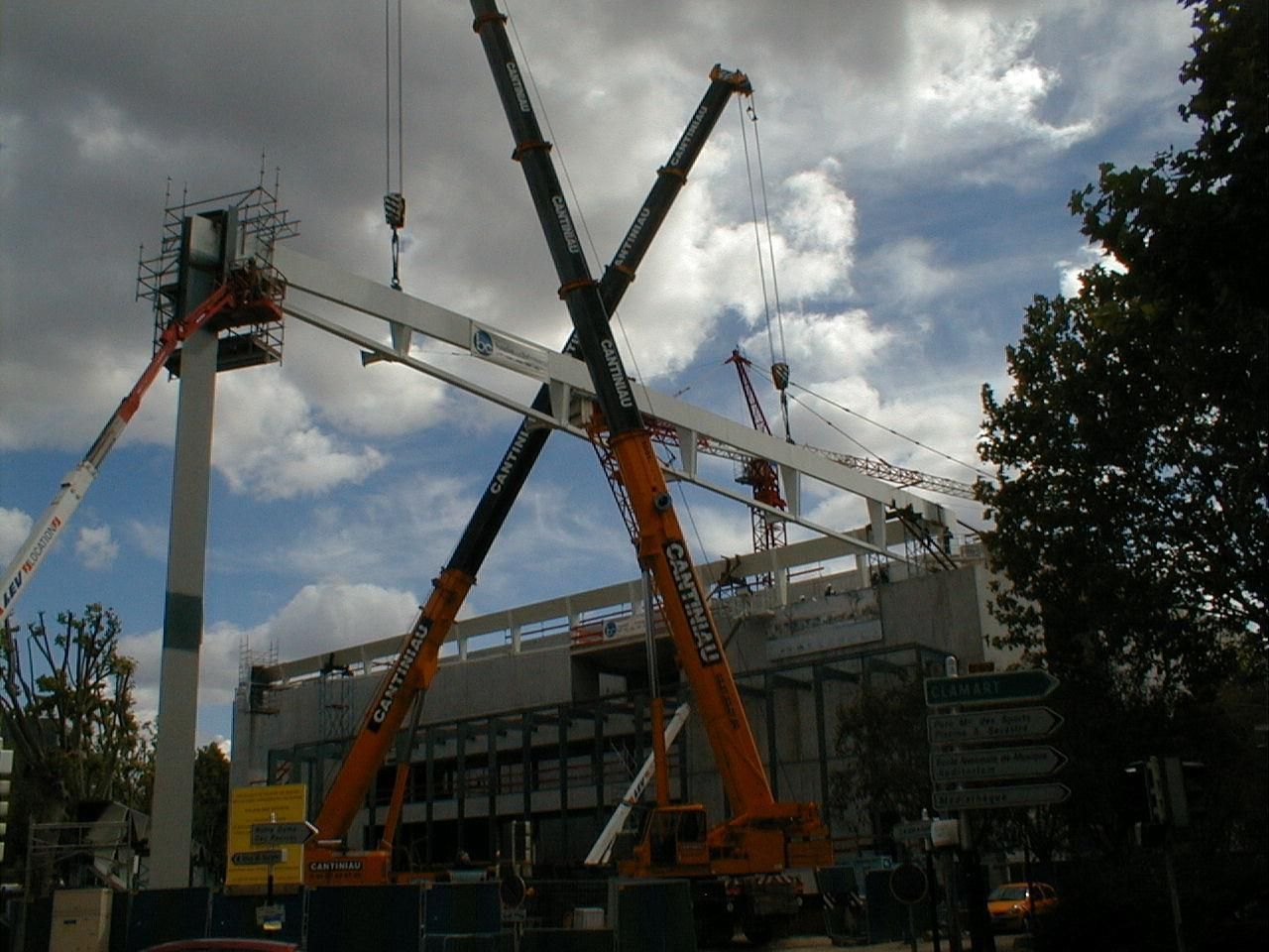 Une grue soulève un bâtiment dans un camion.