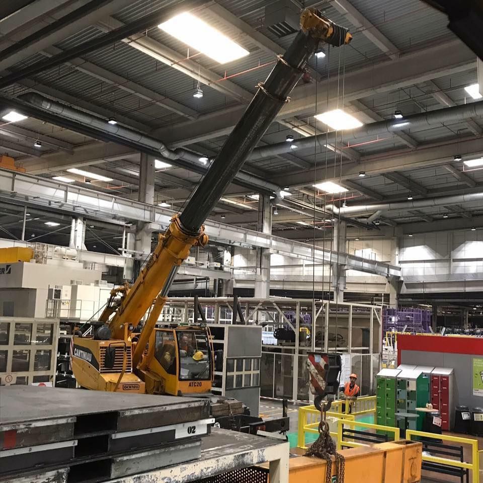 Une grue soulève un morceau de métal.