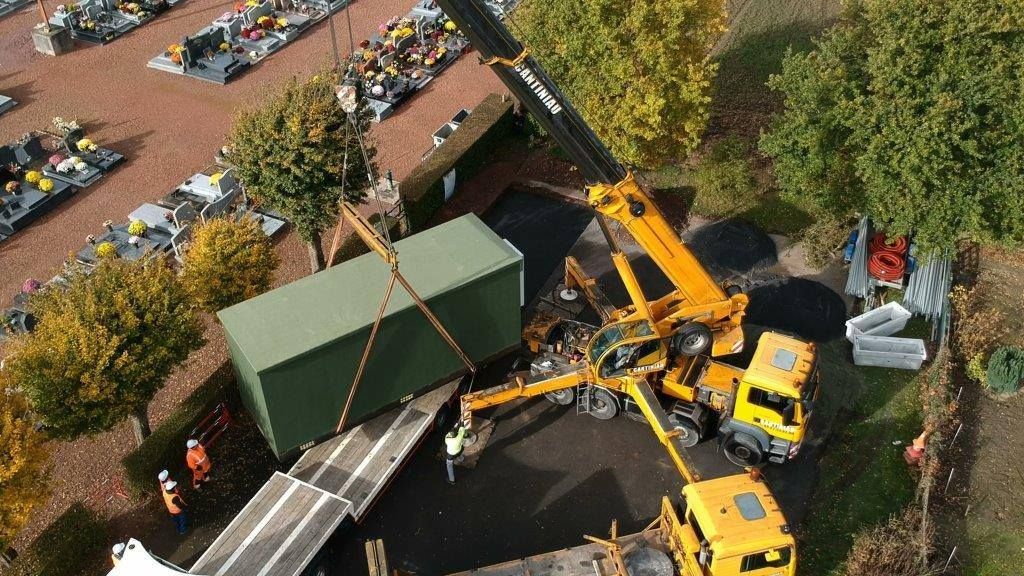 Une grue est vue au milieu du site de l'ancien bâtiment sur le site est en cours.
