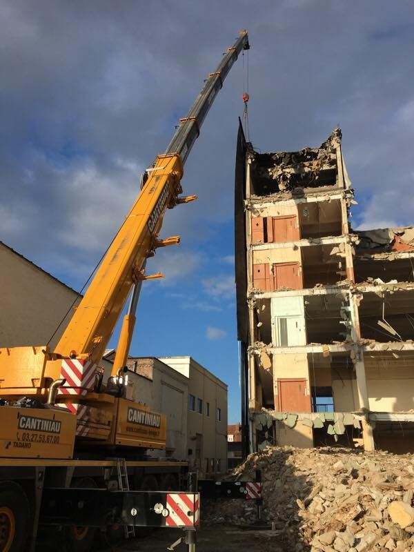 Une grue soulève un gros tas de gravats sur le site.