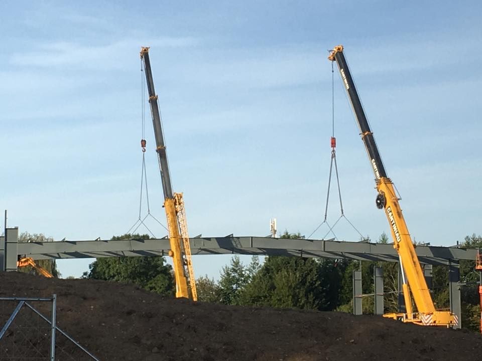 Deux grues sont au sommet d'un tas de terre.