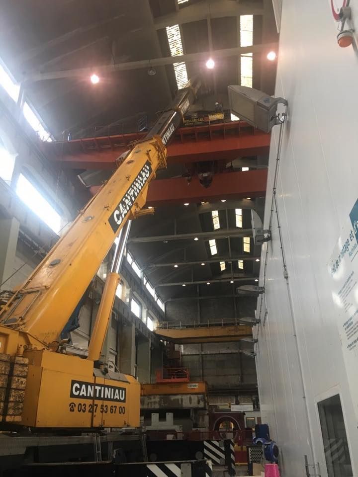 Une grue soulève un gros morceau de métal.