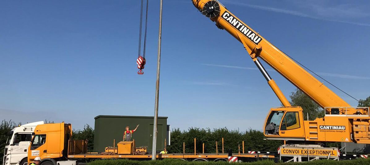 Une grue soulève un grand conteneur dans le camion.
