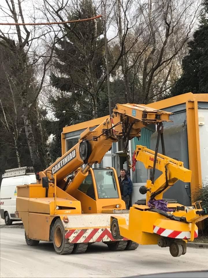 Une grue jaune est garée sur le bord de la route.
