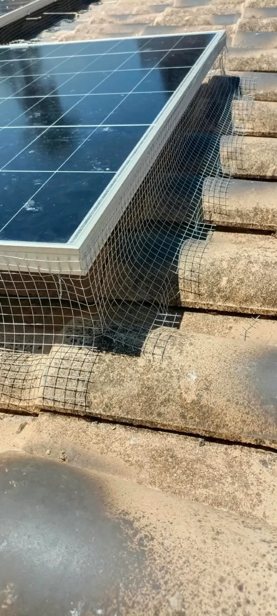 Paneles solares instalados en un tejado de tejas, vistos desde arriba.