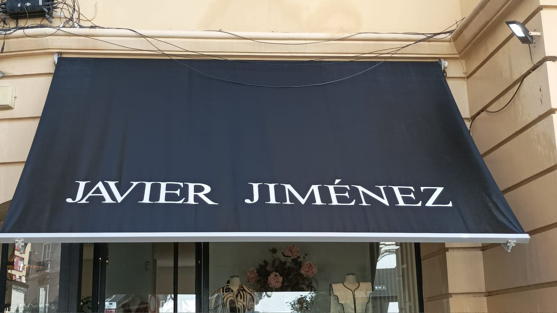 Toldo negro sobre una tienda; se lee 