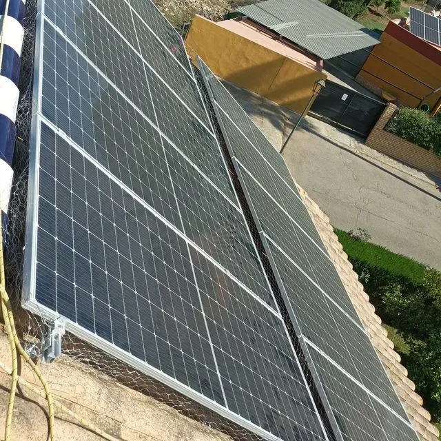 Paneles solares instalados en un tejado de tejas, que reflejan la luz solar.