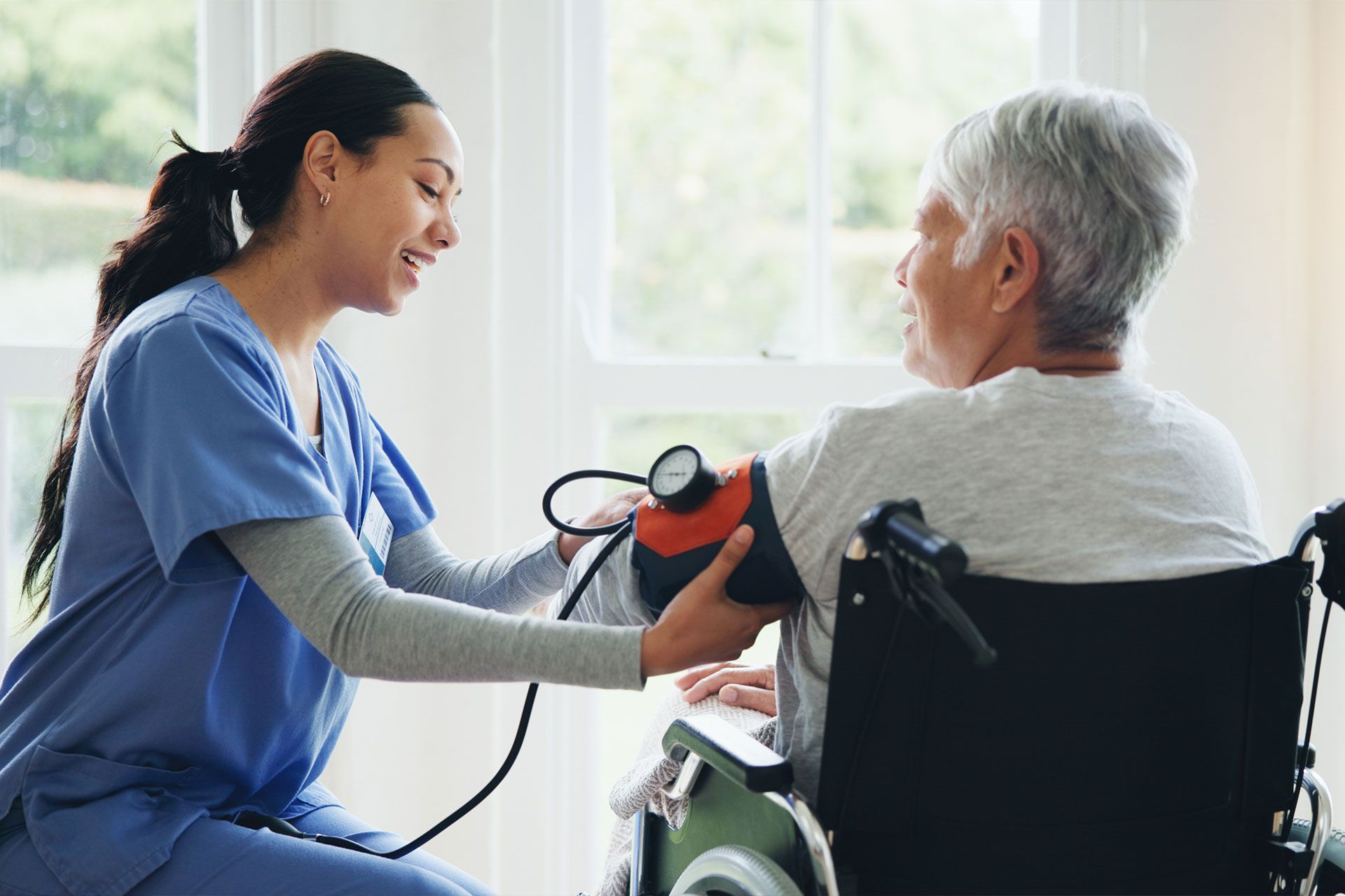 Pflegekraft messt des Bluthochdrucks einer Seniorin