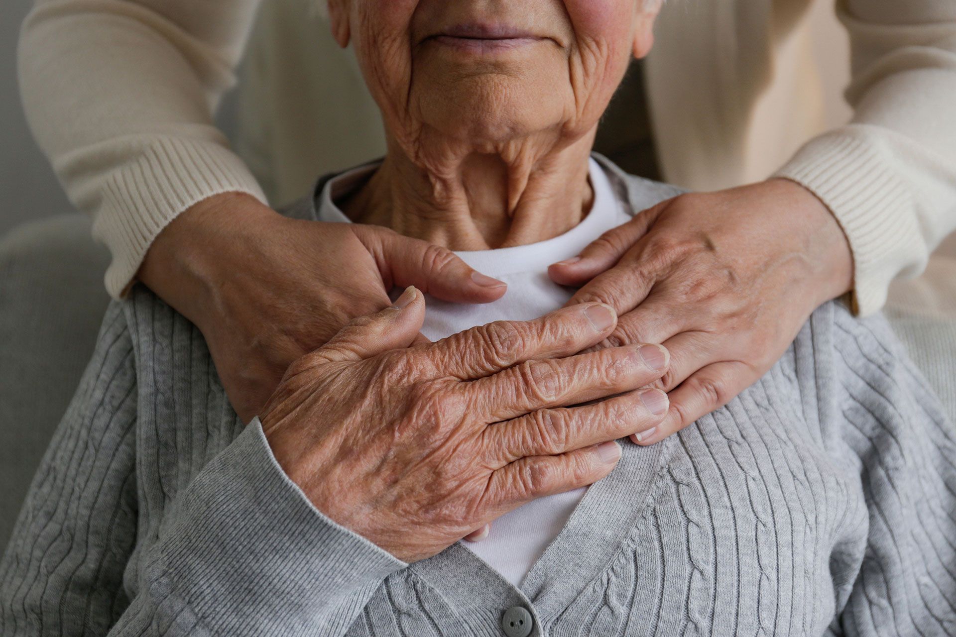 Eine ältere Frau bekommt von einer Pflegekraft eine Massage.
