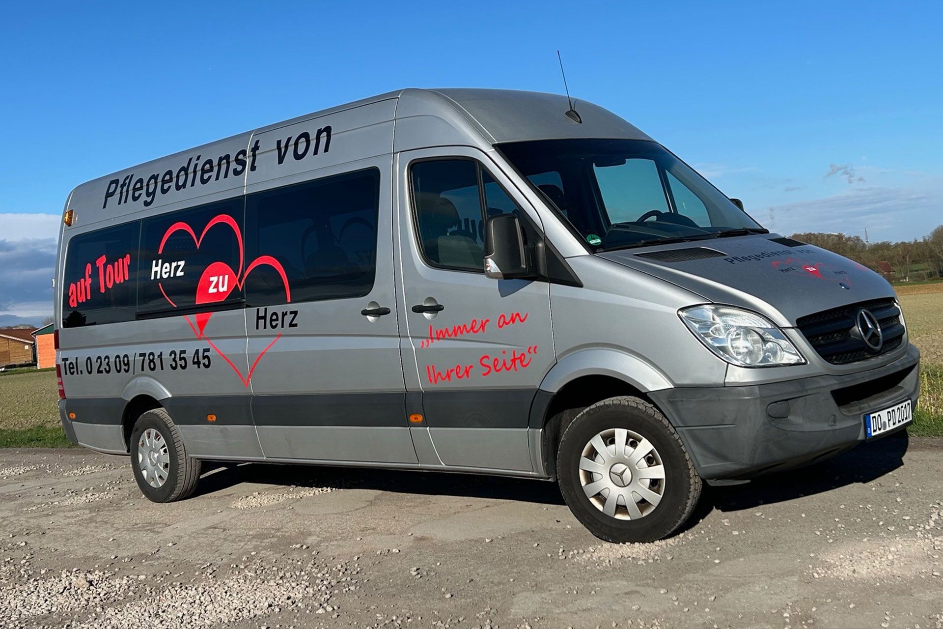 Ein silberner Lieferwagen von dem Pflegedienst von Herz zu Herz