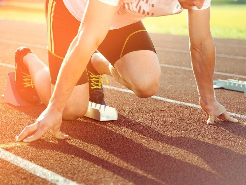 Un corredor se prepara para correr en una pista.