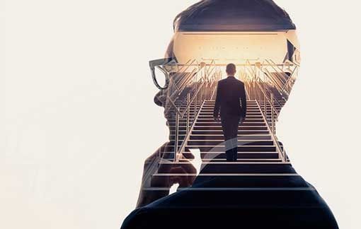 Una doble exposición de un hombre con gafas bajando escaleras.