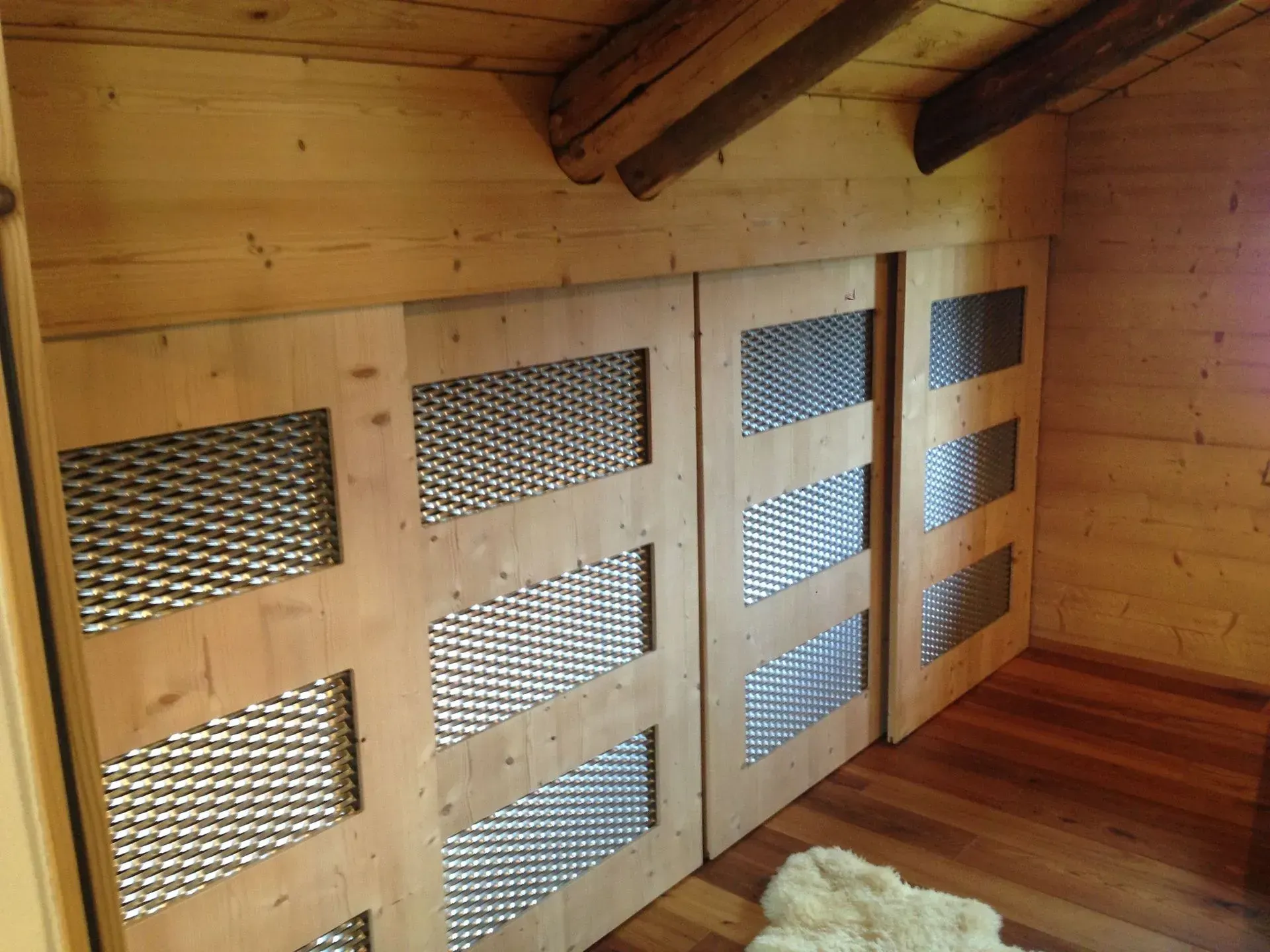 Une pièce en bois avec des portes coulissantes et un tapis sur le sol