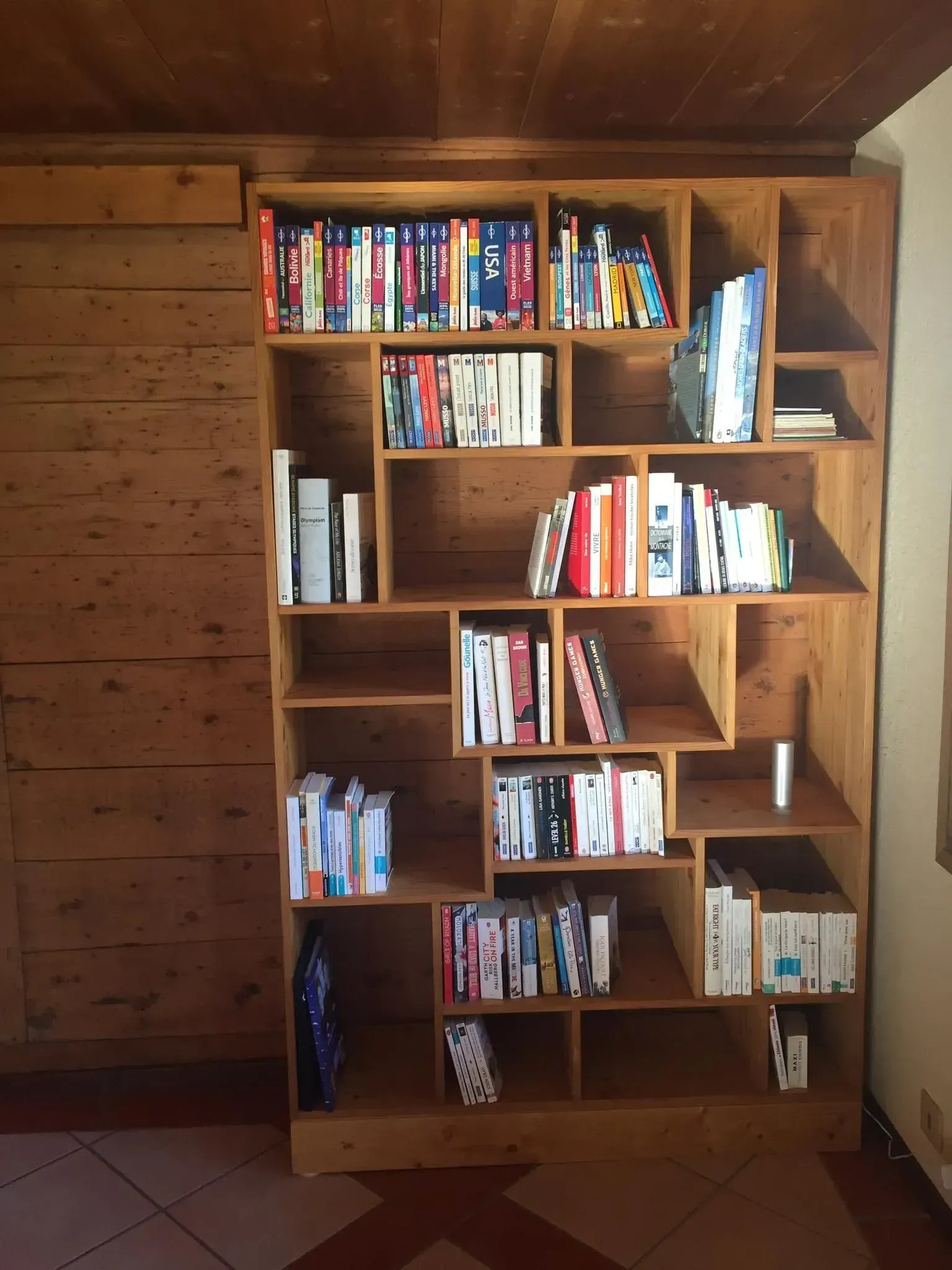 Une étagère en bois remplie de livres dans une pièce