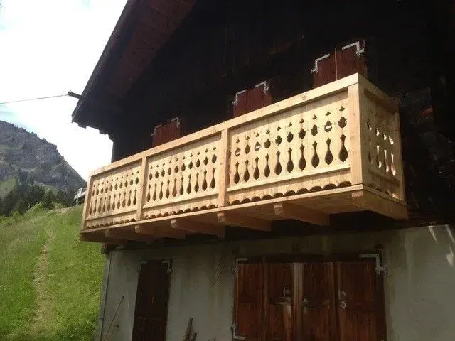 Un balcon en bois avec une montagne en arrière-plan
