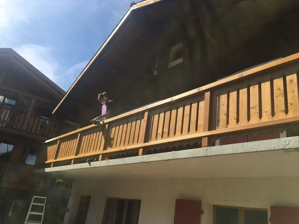Une femme se tient sur le balcon d'une maison