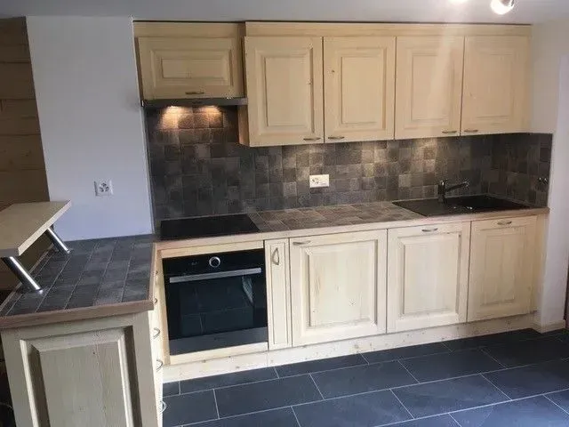 Une cuisine avec une cuisinière, un four, un évier et des armoires.