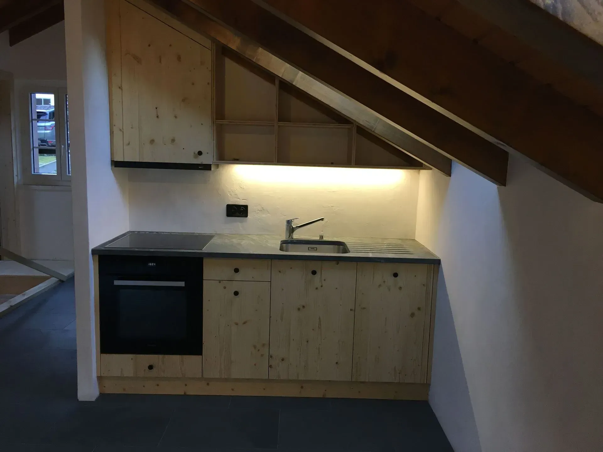 Une cuisine vide avec des armoires en bois et un évier