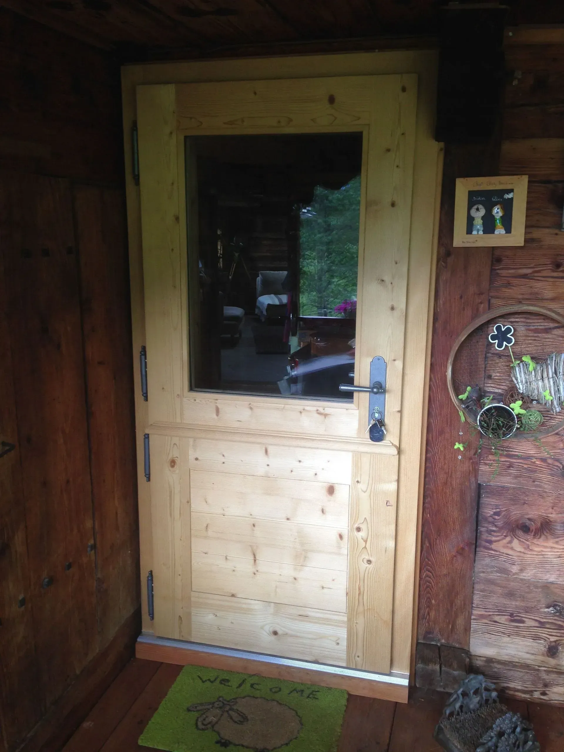 Une porte en bois avec une fenêtre en verre dans une maison en bois