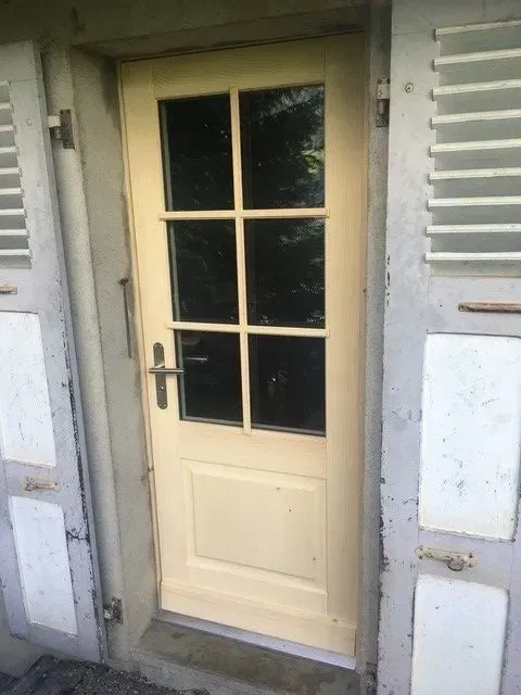 Une porte blanche avec des volets sur le côté