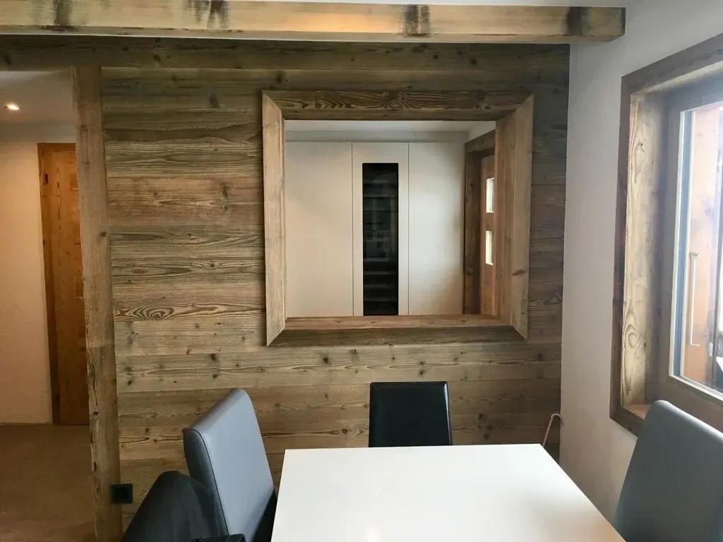 Une salle à manger avec une table et des chaises et un mur en bois.