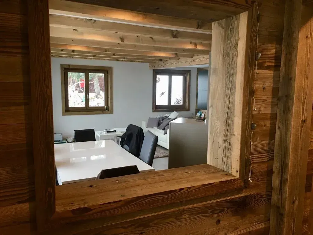 Une vue d'un salon à travers une fenêtre en bois.