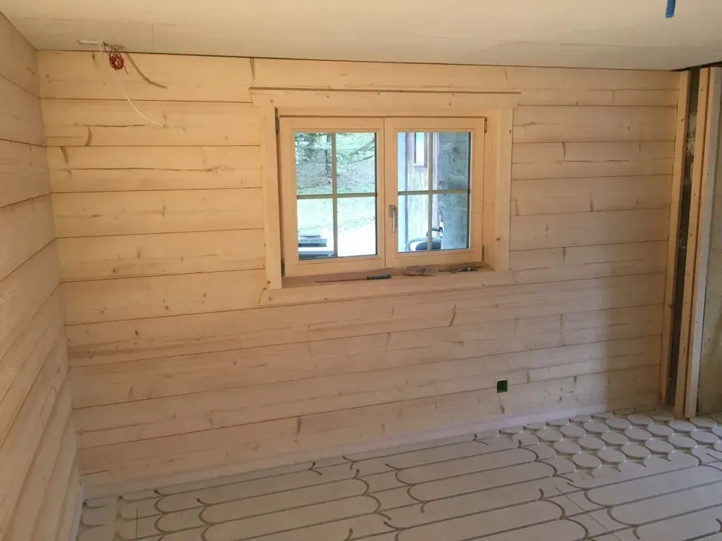 Une pièce avec des murs en bois et une fenêtre à l'intérieur